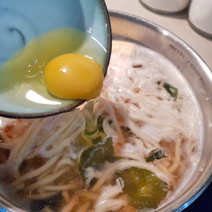 Ei in die Udon-Brühe geben
