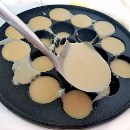 Takoyaki-Teig zuerst in die äusseren kälteren Löcher füllen