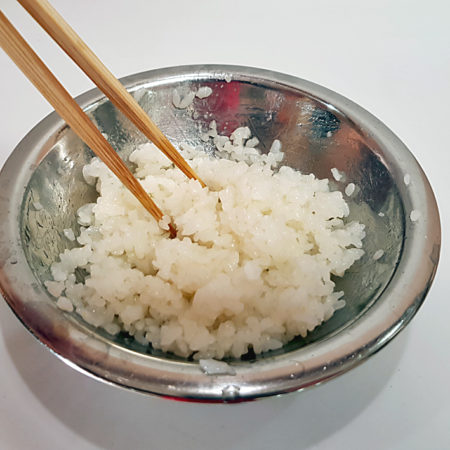 Reis mit Sushi-Essig mischen