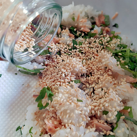 Weißen Sesam zur Reis-Lachs-Shiso-Mischung geben