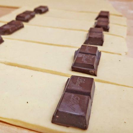 Pains au Chocolat-Teigstücke (20x6,33 cm) mit Schokolade belegen